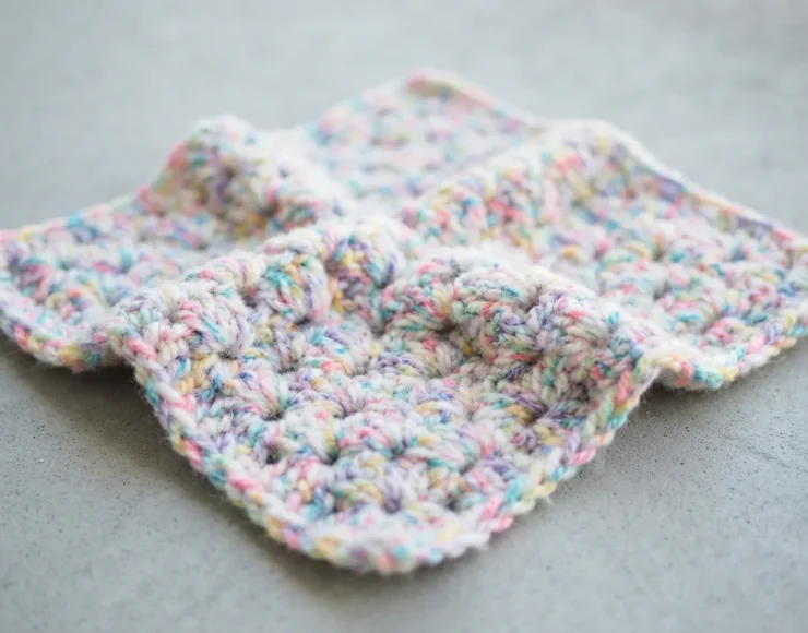 Washed and dried crocheted blanket swatch in soft Birthday Cake colors.